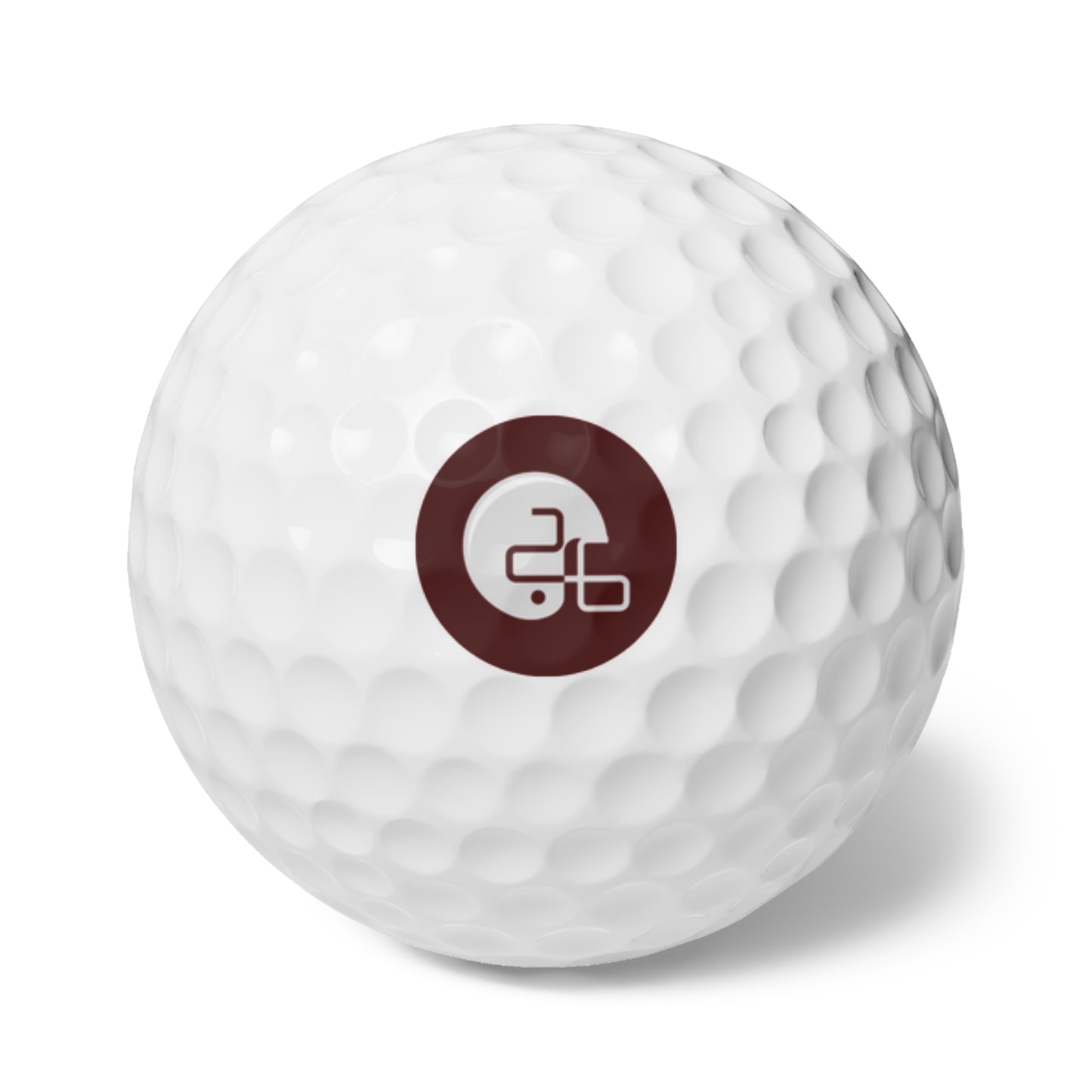 A Pup26 Aggie golf ball with a maroon Printify logo on it.