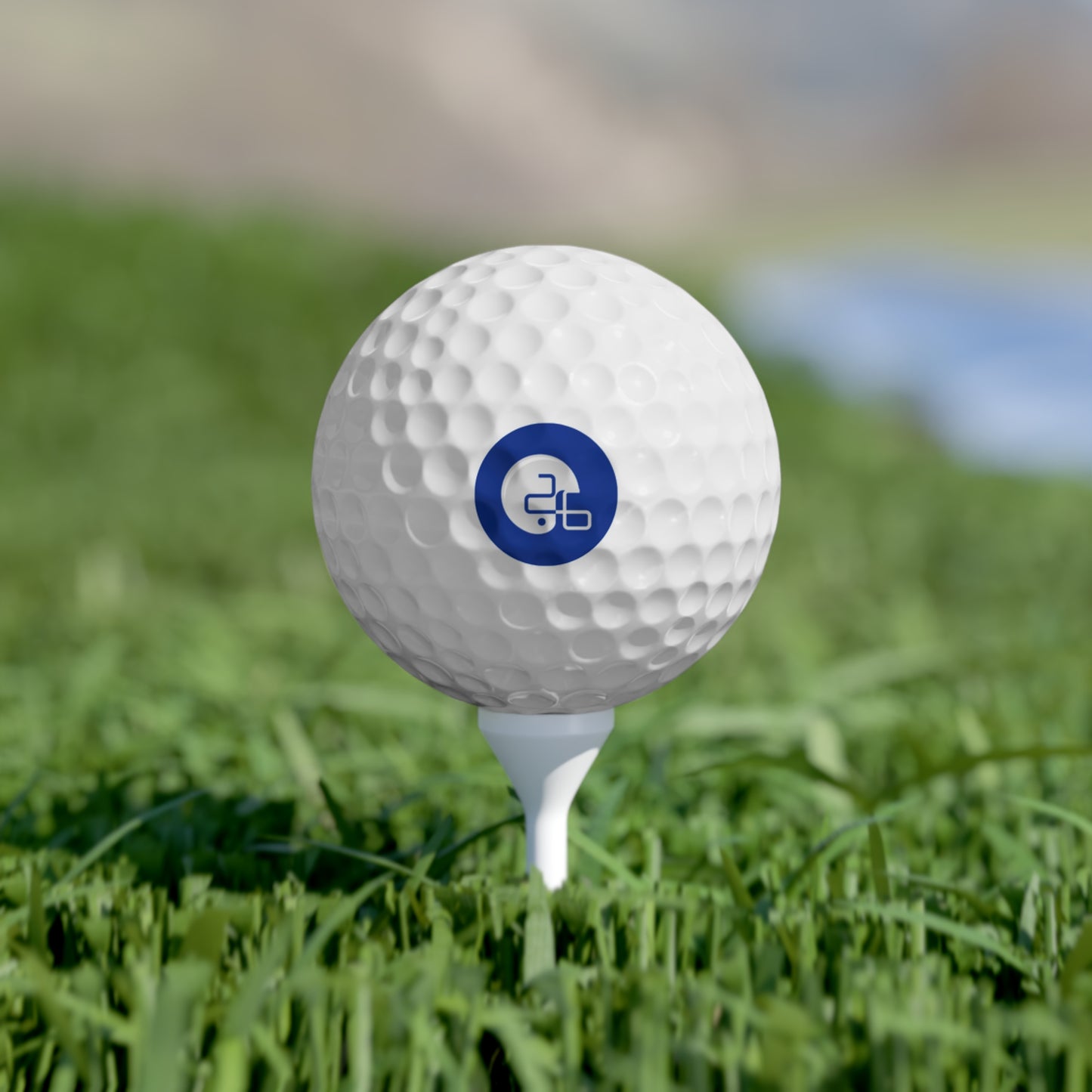 A Pup26 Dallas Cowboys golf ball with a logo on it in the grass. Brand Name: Printify.