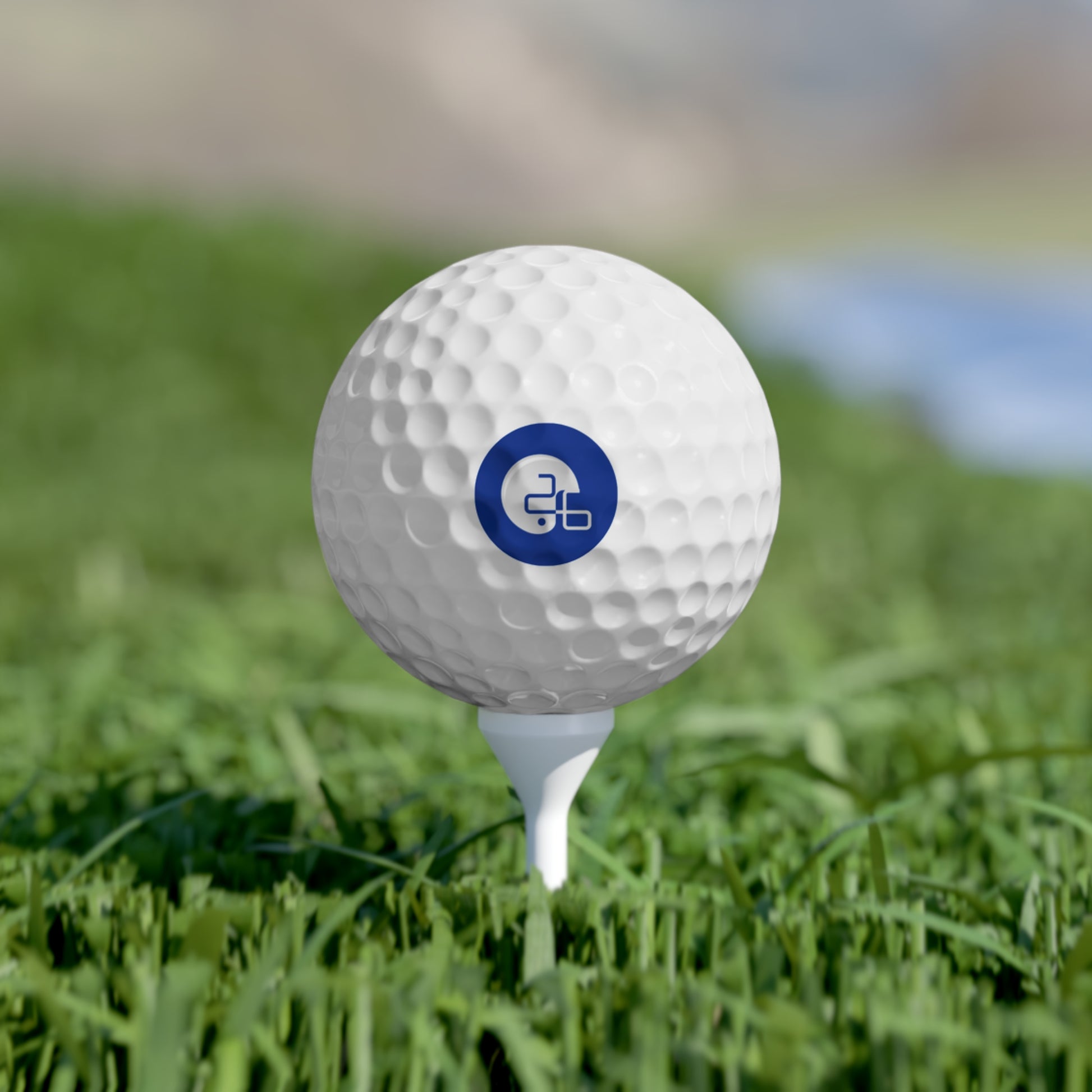 A Pup26 Dallas Cowboys golf ball with a logo on it in the grass. Brand Name: Printify.